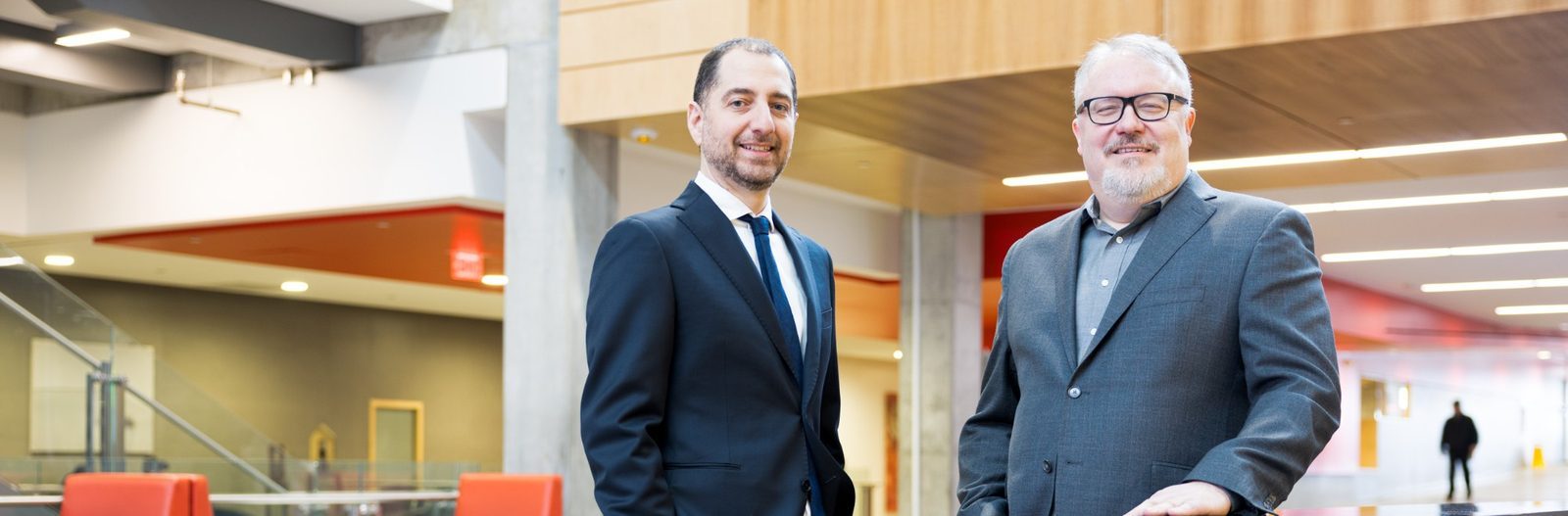 Panos Panagiotakopoulos and Kent Peel standing together in a bright atrium